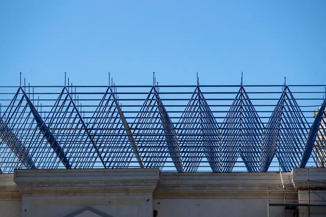 Ossature métallique de toiture en cours de montage sur un bâtiment