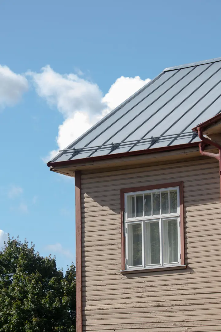 Toiture métallique claire sur une maison en bois, ciel dégagé