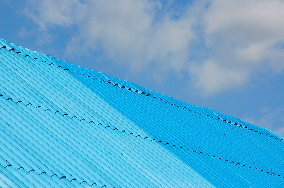 Tôle ondulée bleue vue en contre-plongée contre le ciel